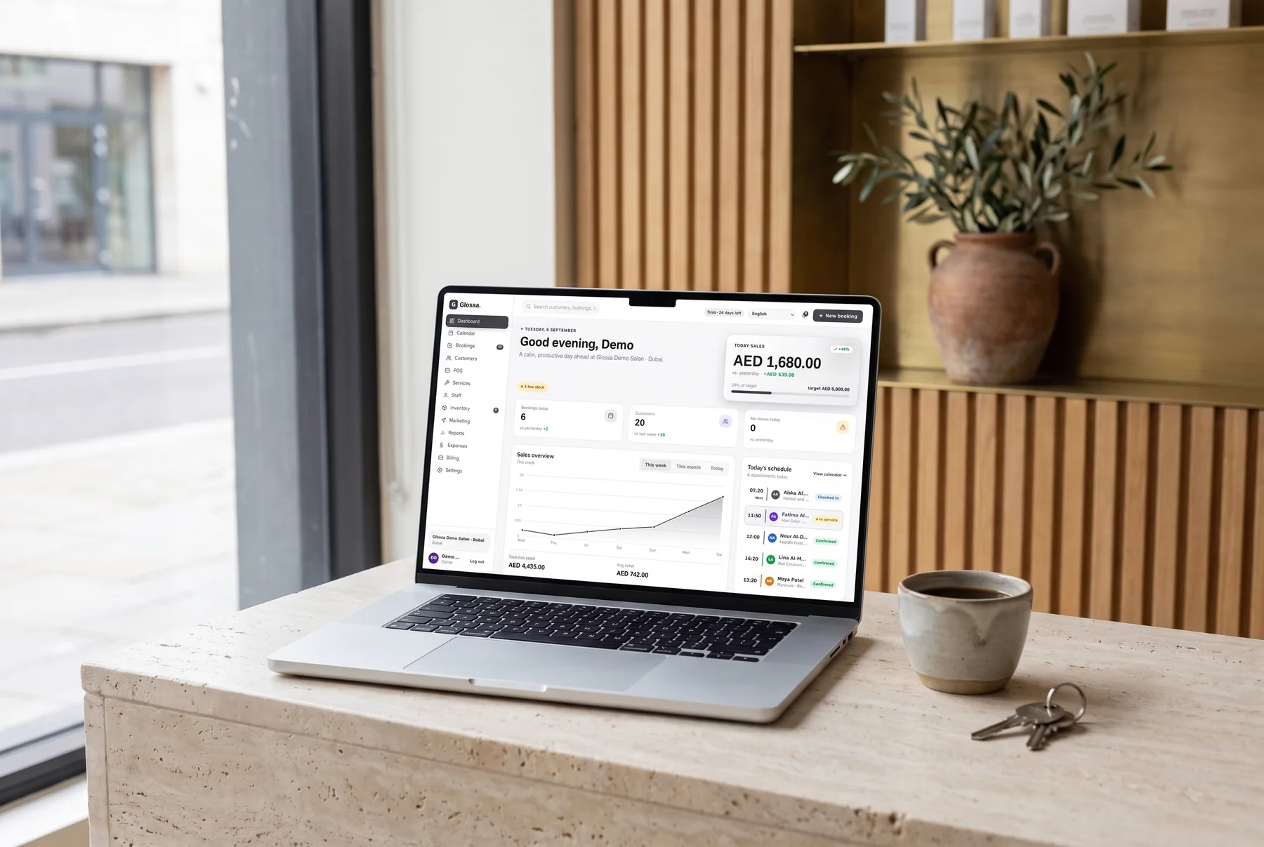 The Glossa dashboard open on a laptop at a salon reception counter