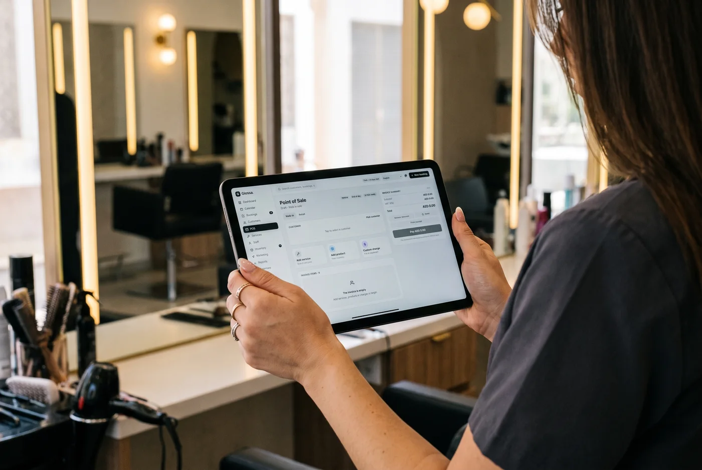 A stylist taking a payment on a tablet at the styling station